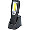Zwarte LED-werkplaatslamp met oplaadstation. Boven een lichtveld, daaronder het KS TOOLS logo en oplaadindicator.